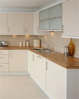 A light-coloured kitchen with a timber worktop.