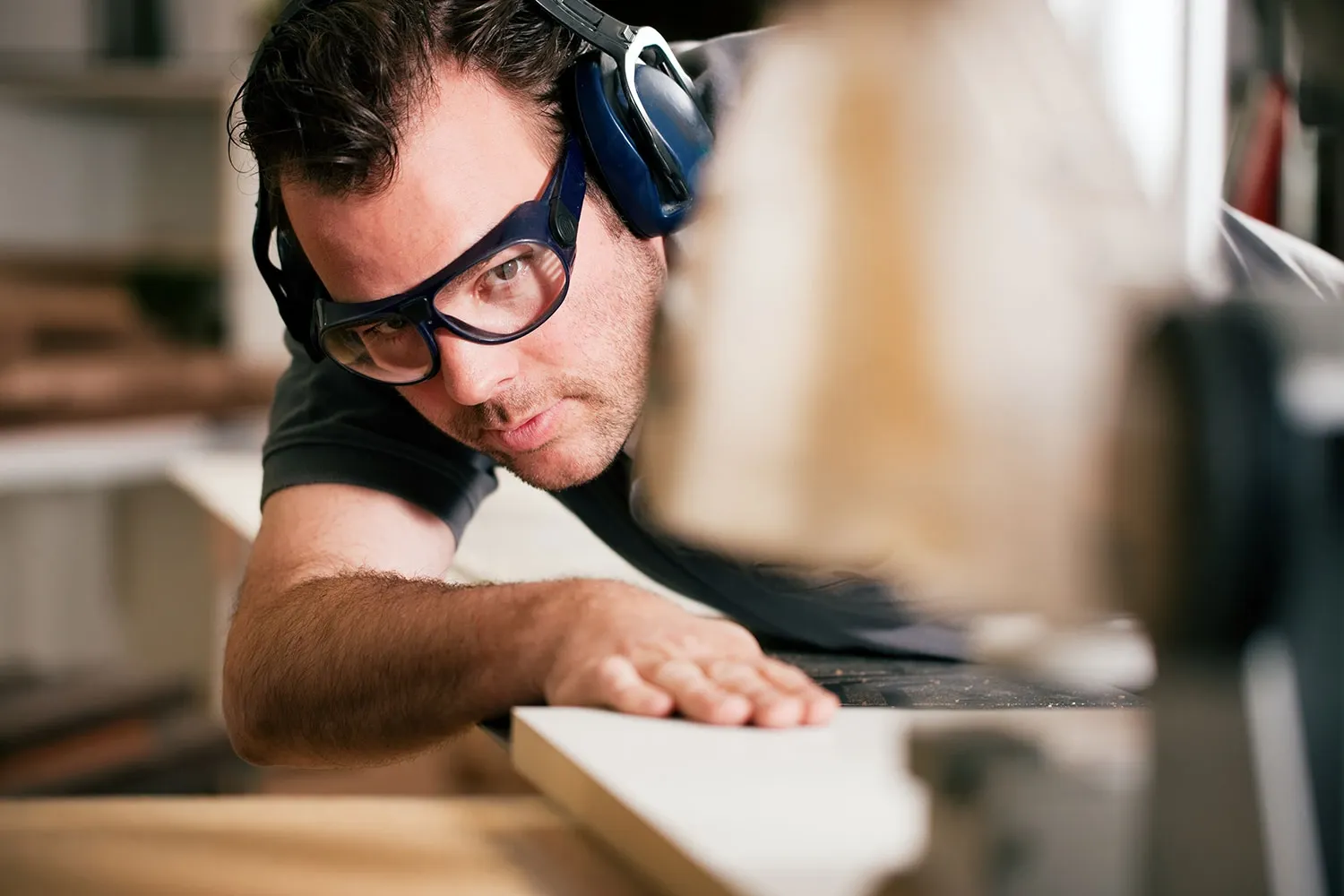 A close view of a craftsperson shaping a timber piece by hand.